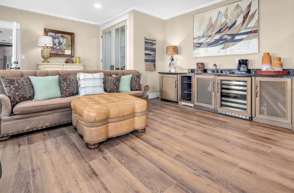 Sink into the plush sofa and unwind in this inviting space, where coastal-inspired art and warm wood tones create a relaxed, welcoming atmosphere perfect for your getaway.