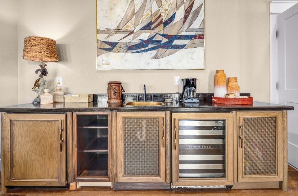 Sip morning coffee at your fully stocked wet bar, complete with wine fridge, sink, and coastal-inspired décor that sets a relaxed, beachy vibe.