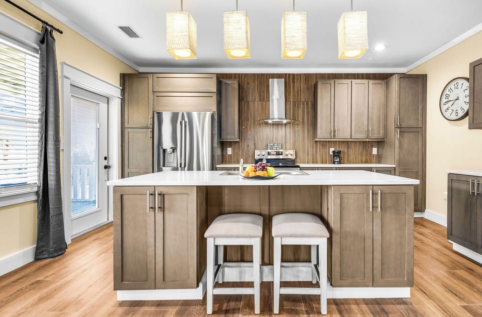 Cook your favorite meals in this stunning modern kitchen with gleaming countertops, stainless steel appliances, and island seating for casual dining.