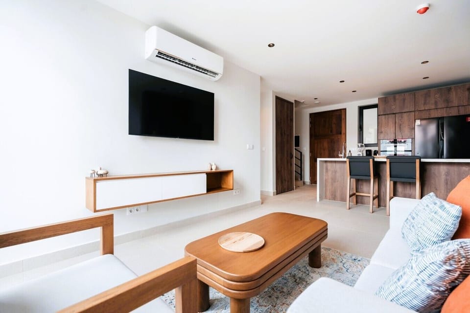 Unwind in the spacious, open-plan living area. Floor-to-ceiling glass doors open to the balcony, filling the room with natural light