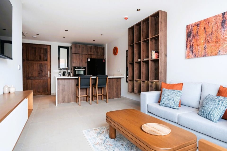 Unwind in the spacious, open-plan living area. Floor-to-ceiling glass doors open to the balcony, filling the room with natural light