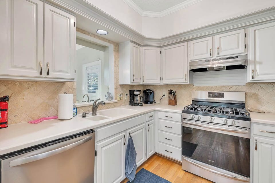 Your fully equipped kitchen features crisp white cabinets, stone countertops, and stainless appliances—perfect for whipping up morning coffee or evening meals.