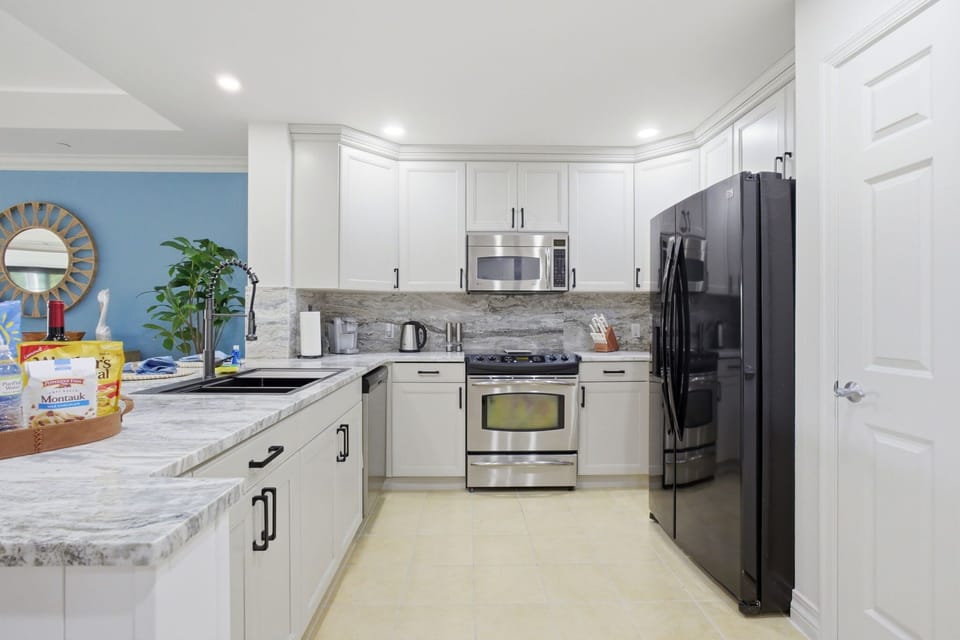 Modern chef’s kitchen featuring stainless steel appliances, granite countertops, and ample space to gather