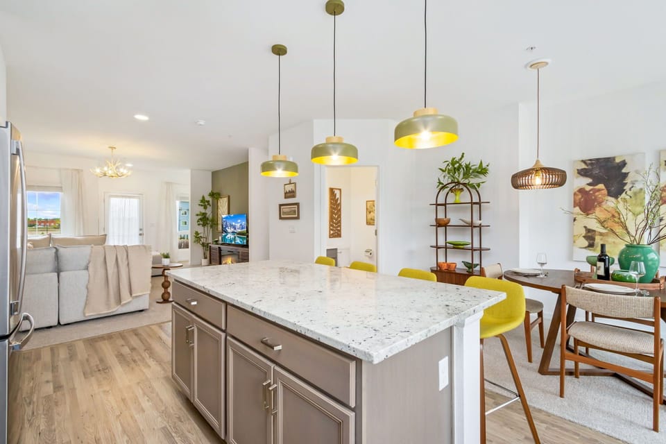 Gather around your spacious kitchen island with elegant pendant lights overhead, where marble countertops invite morning coffee rituals and meal prep becomes a joy in your open, sunlit retreat.