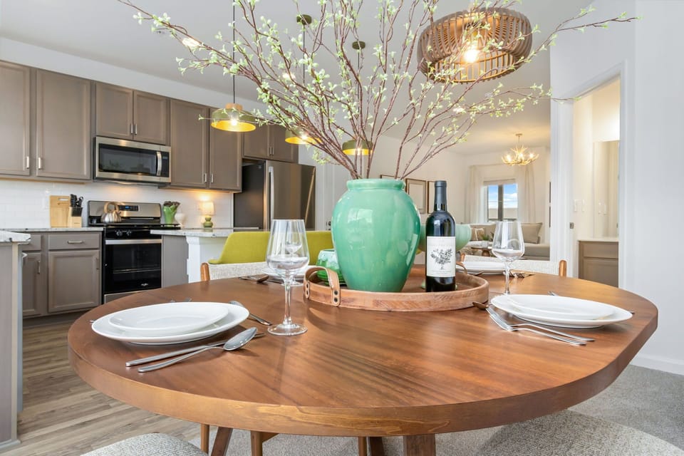 Gather around this inviting dining space, where your meals are framed by warm light, thoughtful décor, and a fully equipped kitchen ready for home-cooked feasts or morning coffee.