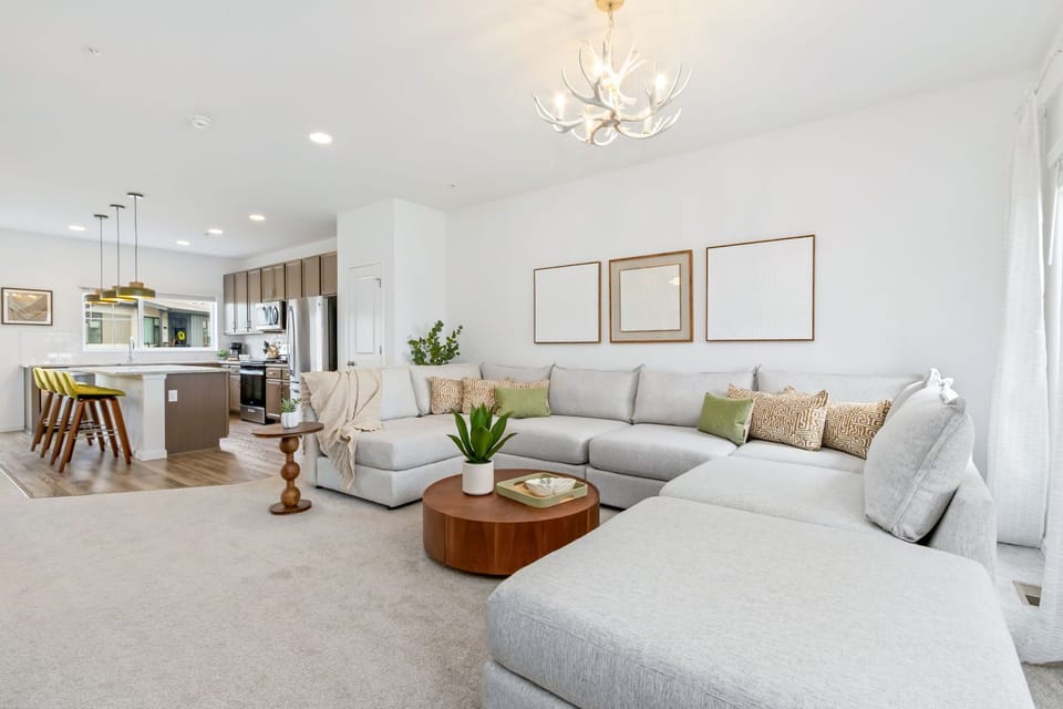 Settle into this bright, open living space with plush seating and natural touches. The stylish antler chandelier and modern kitchen invite you to relax and feel completely at home.