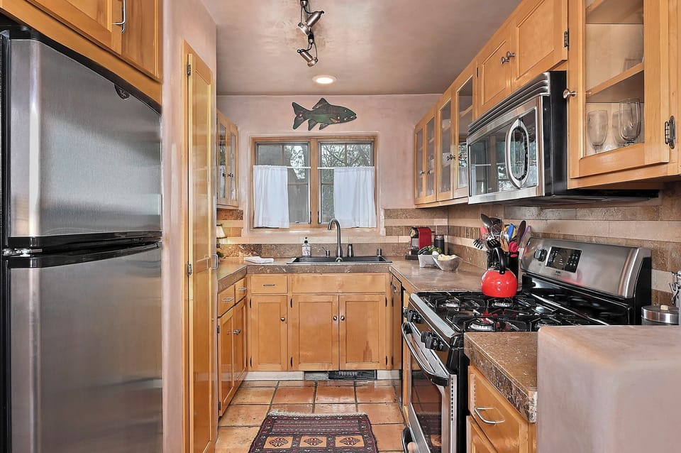 Your fully equipped kitchen features granite counters, stainless appliances, and warm wood cabinetry—perfect for preparing memorable meals during your stay.