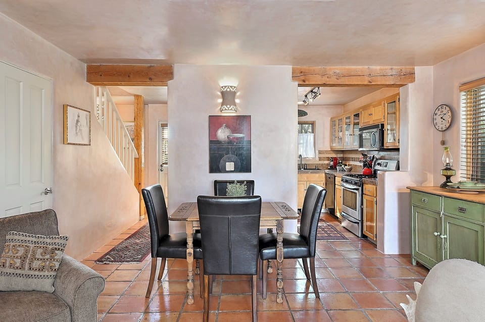 Your open-concept space flows beautifully from dining to kitchen, with exposed beams and rustic charm creating the perfect setting for memorable meals together.