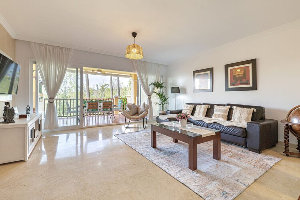 Spacious & Bright Living Area: Light-filled, open-plan living room with large Smart TV and plenty of comfortable seating.