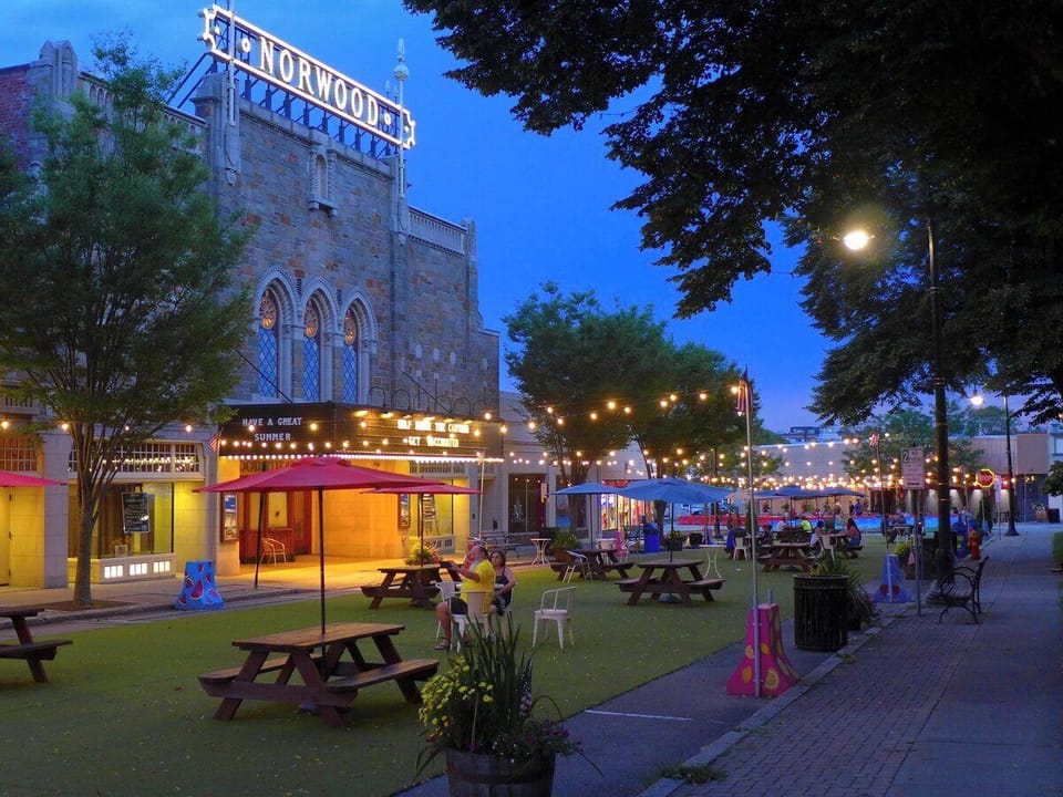 Charming theater district with patio seating and glowing string lights