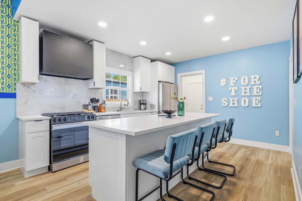 Brighten your stay in this modern kitchen! The spacious island and stainless steel appliances make hosting a breeze. With its unique decor and airy atmosphere, this colorful space is designed for memorable meals and relaxing mornings at home.