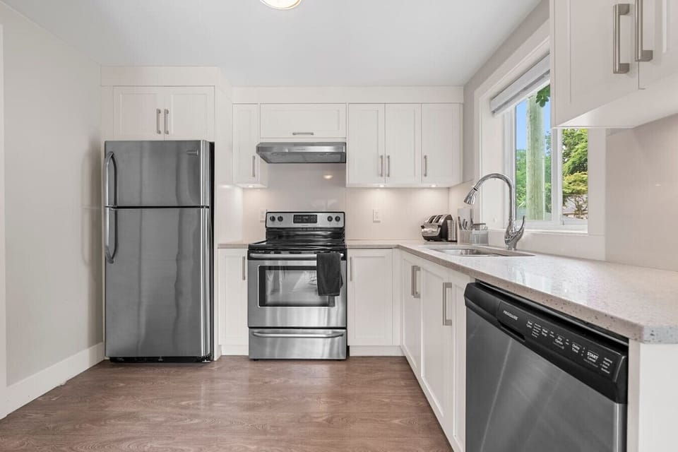 Modern Kitchen: Sleek stainless steel appliances and bright daylight await your culinary adventures!