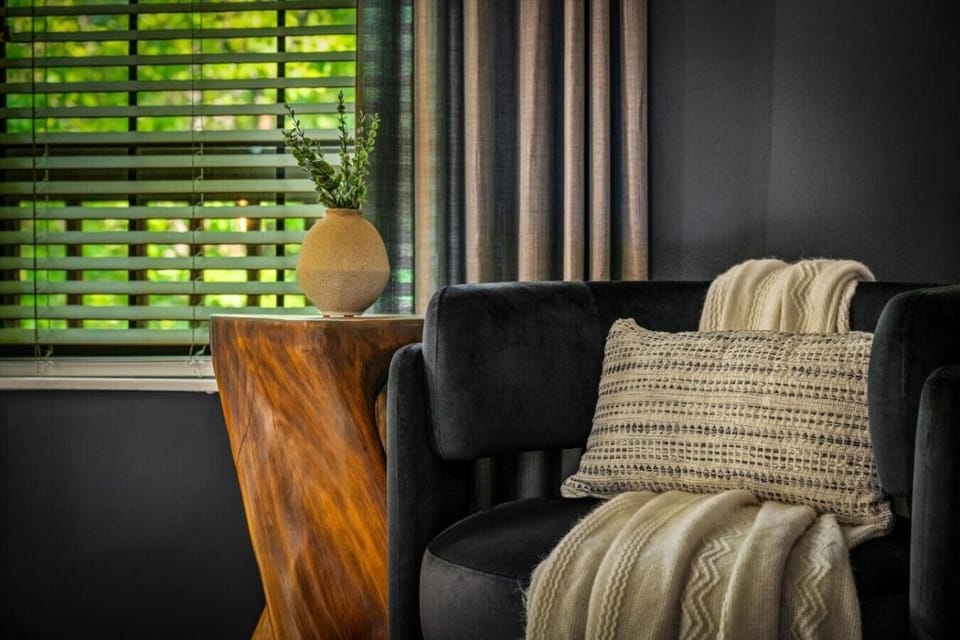 Cozy details with comfortable seating, soft textures, and wooded views for a relaxing cabin stay (Upstairs bedroom on right)