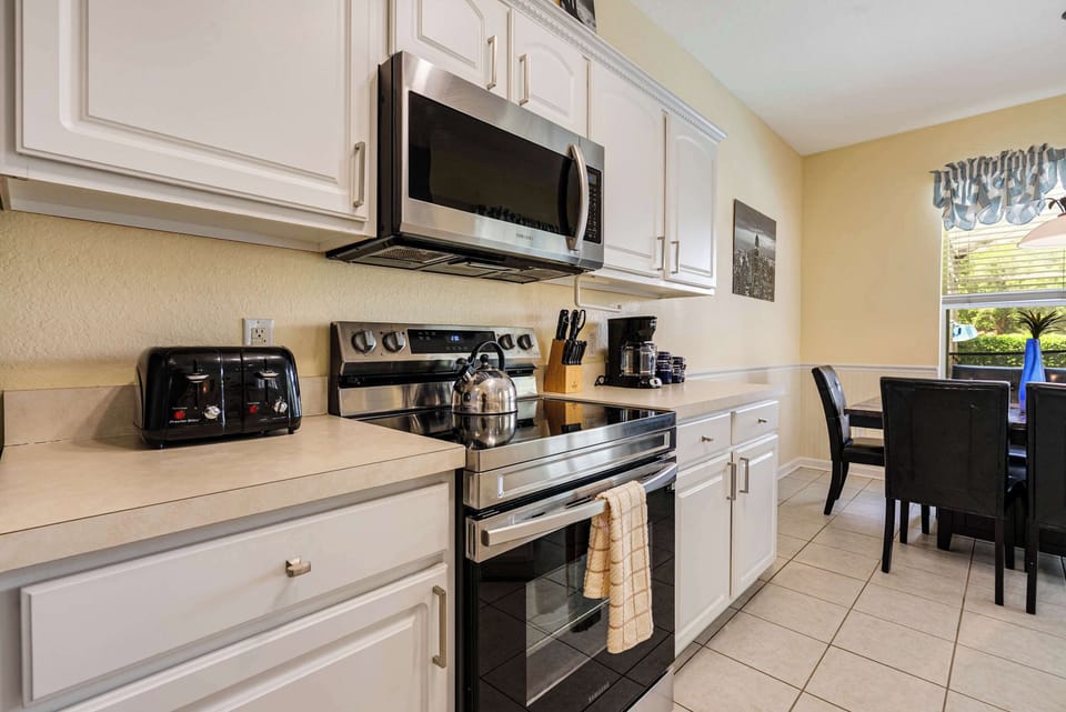 Modern kitchen with stainless steel appliances and a bright dining area.