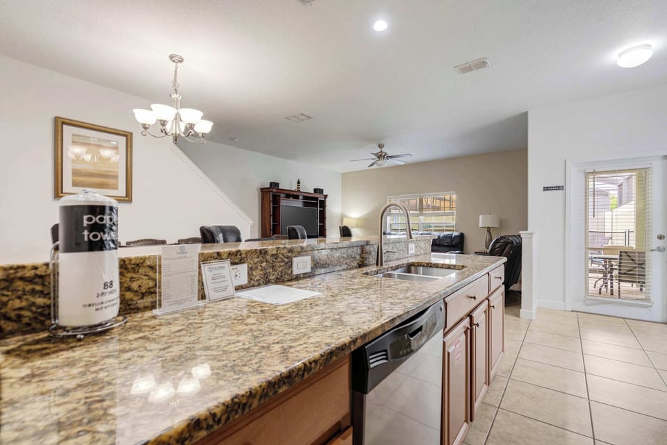 Spacious kitchen with granite countertops and a view into the living area.