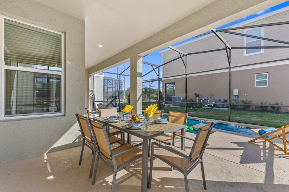 Screened-in patio with a table for 6 beside the pool-perfect for breezy alfresco breakfasts and afternoon snacks in a relaxed resort vibe.