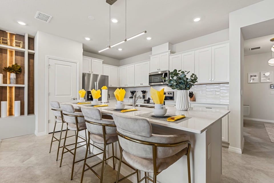 Pull up a seat at the chic island-plush barstools, quartz counters, and stainless appliances make this bright, modern kitchen perfect for casual breakfasts and chef nights.