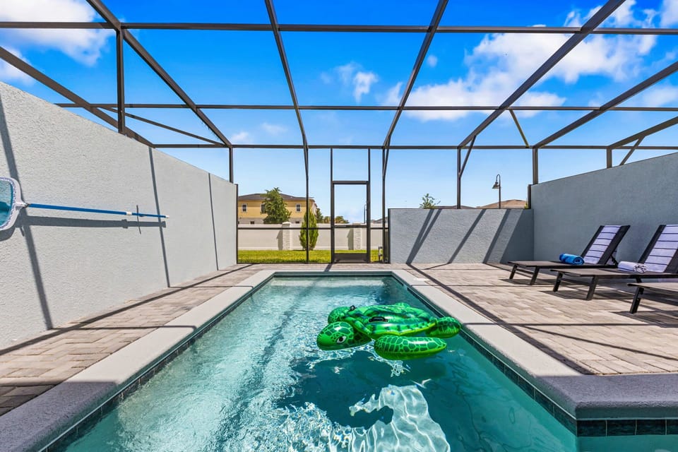 Soak up the sun at your private screened pool-sparkling water, fun floats, and cushioned loungers with a clear backyard view.