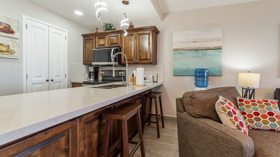 Bar stools adorn the kitchen counter.