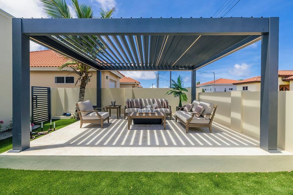 Covered outdoor lounge with pergola, comfortable seating, and private yard. Perfect for relaxing, entertaining, and enjoying indoor-outdoor living.