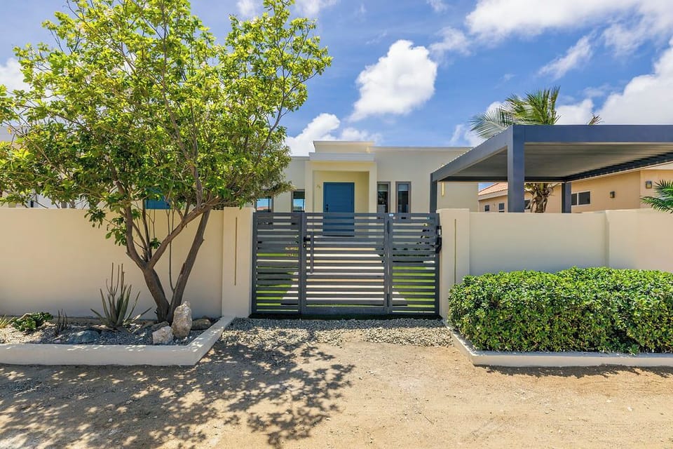 Gated property with private entry, lush landscaping, and clean modern exterior. Designed for privacy, comfort, and a relaxing stay.