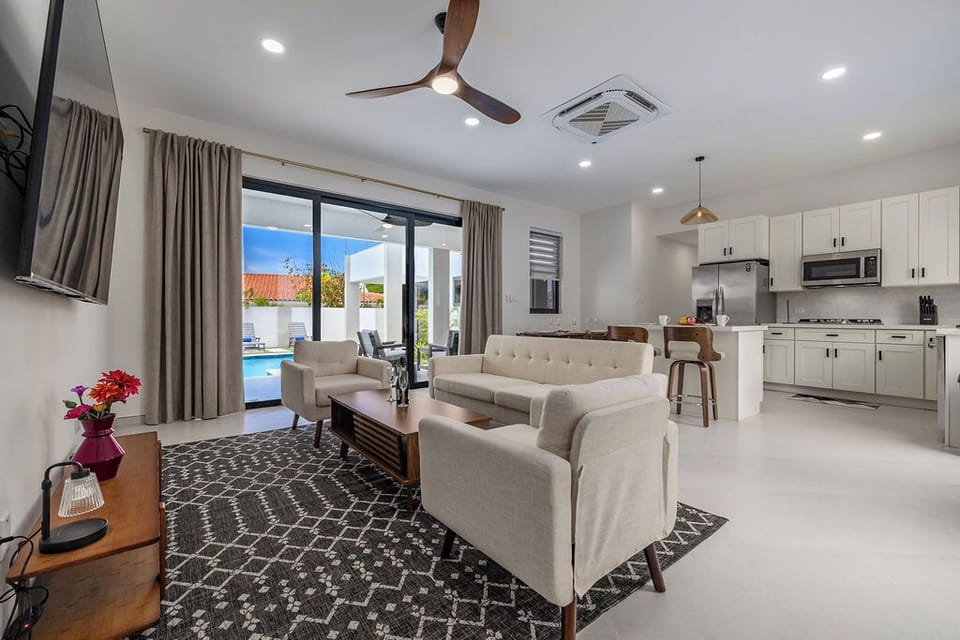Bright open living space with plush seating and direct access to the pool, perfect for relaxing and spending quality time together