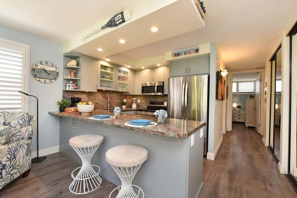 Stylish kitchen with granite countertops, stainless steel appliances, breakfast bar, blender and coffee maker