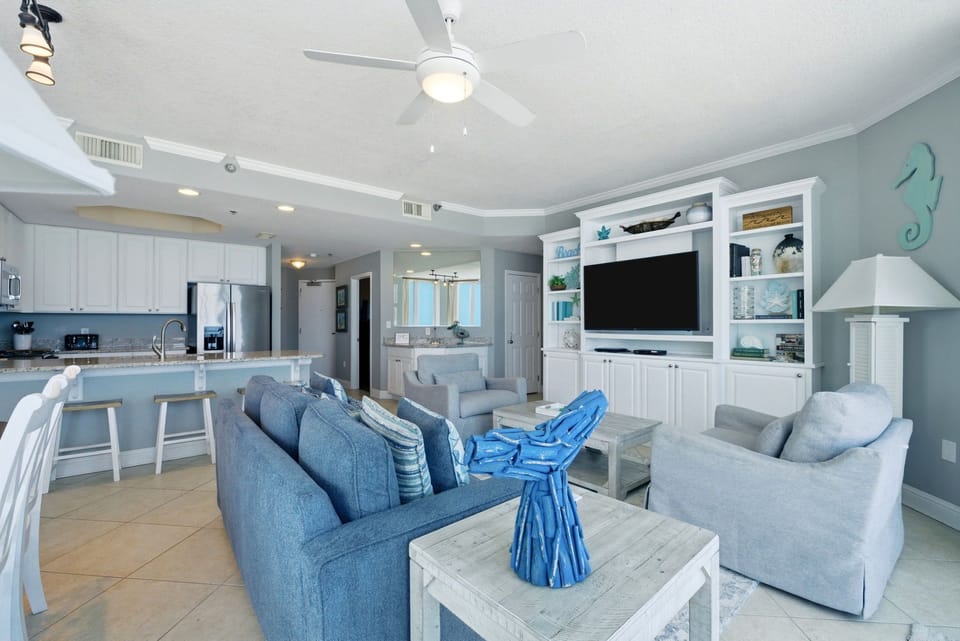 Lighthouse 418- Step into your coastal escape, where airy blues and whites create a breezy, open atmosphere. Relax on soft seating, cook in your fully equipped kitchen, and enjoy modern comforts blended with beachy charm throughout.