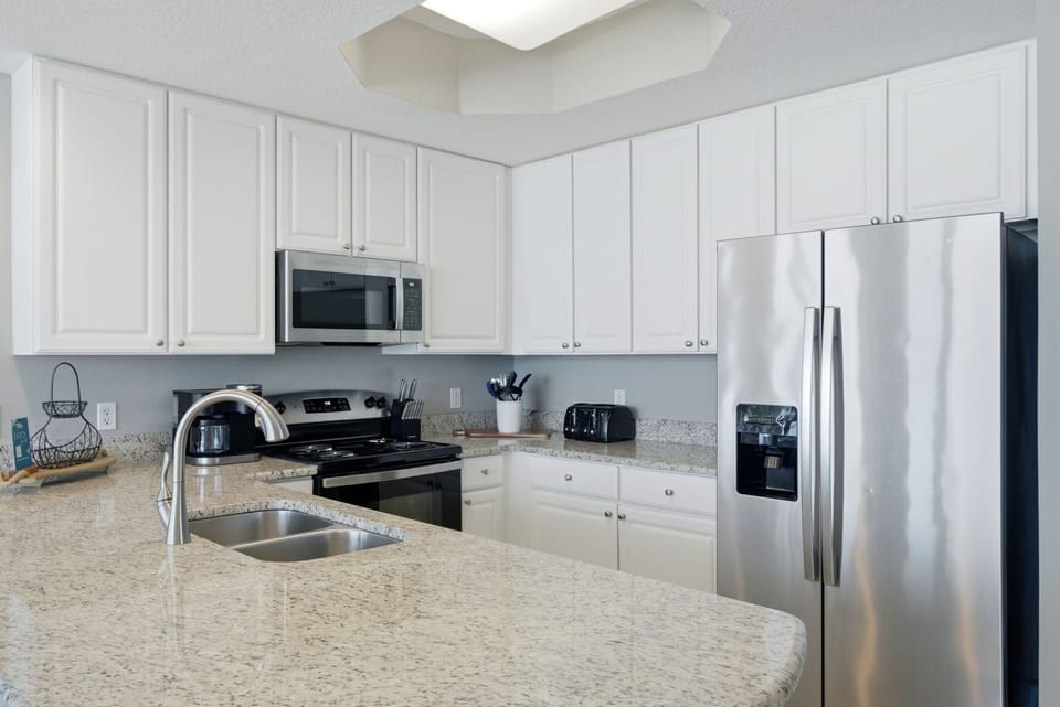 Lighthouse 418- Bright and spacious kitchen equipped with modern appliances, granite countertops, and all the essentials for preparing your favorite home-cooked meals during your stay.