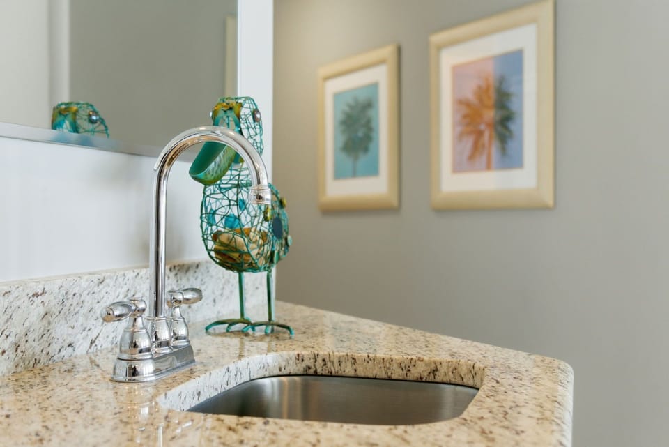 Lighthouse 418- Picture yourself freshening up at this stylish granite vanity with its gleaming faucet and playful coastal décor—your perfect start to a relaxing getaway morning.