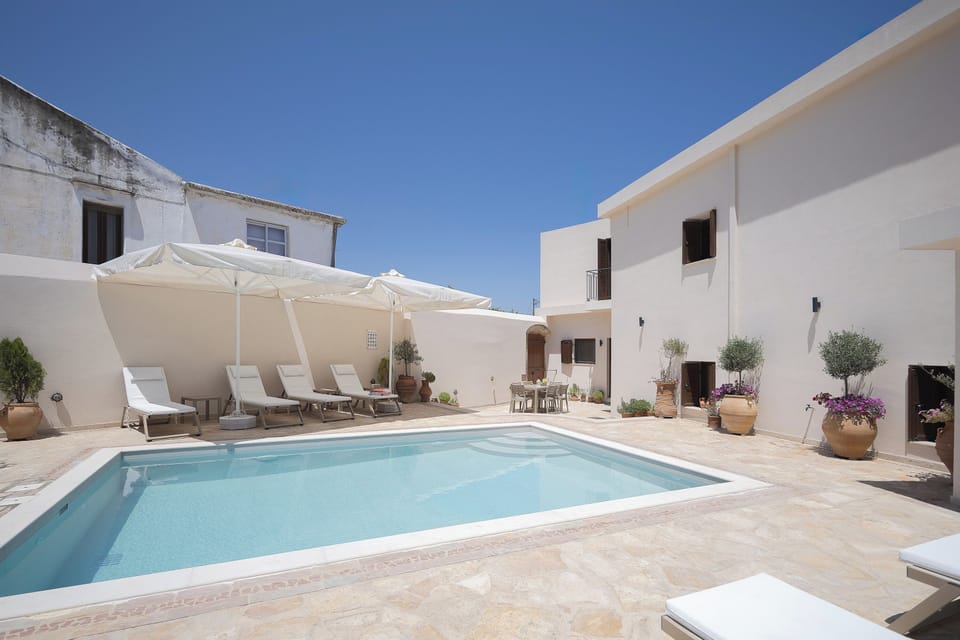 Private 40 sqm swimming pool with sunbeds, umbrellas, and outdoor shower—perfect for relaxing under the Cretan sun in a peaceful village setting.