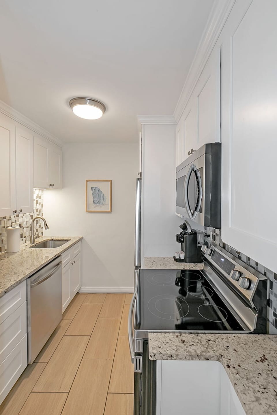 Bright kitchen w/ granite counters, stainless appliances & clean white cabinetry