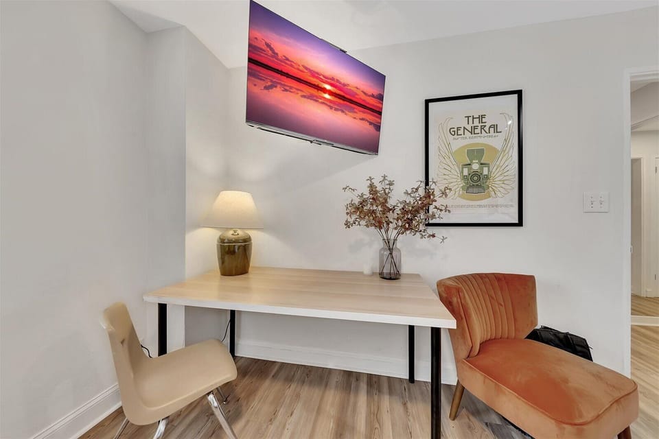 Cozy workspace w/ desk, seating & wall-mounted TV for work or streaming
