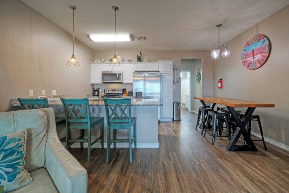 Open-concept kitchen & dining with breakfast bar seating—perfect for group meals and beach-day planning. (Ocean's 96)