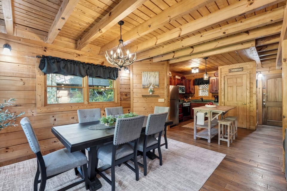 Rustic cabin dining room with warm wood, soft lighting, and a cozy table set for slow, memorable meals.