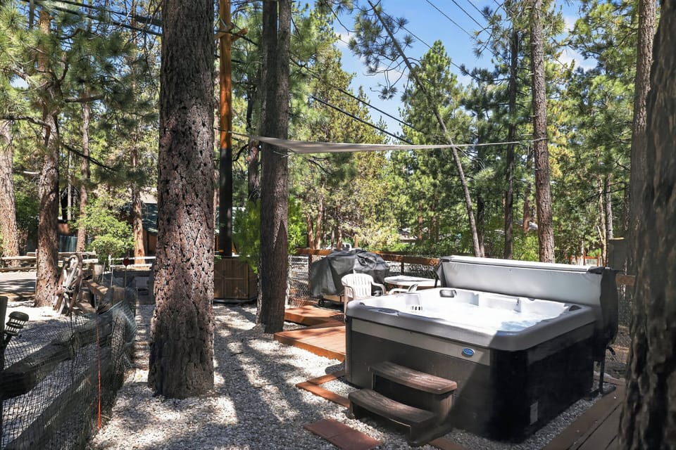 Soak among the pines in the private hot tub, shaded by a sail canopy for added comfort.