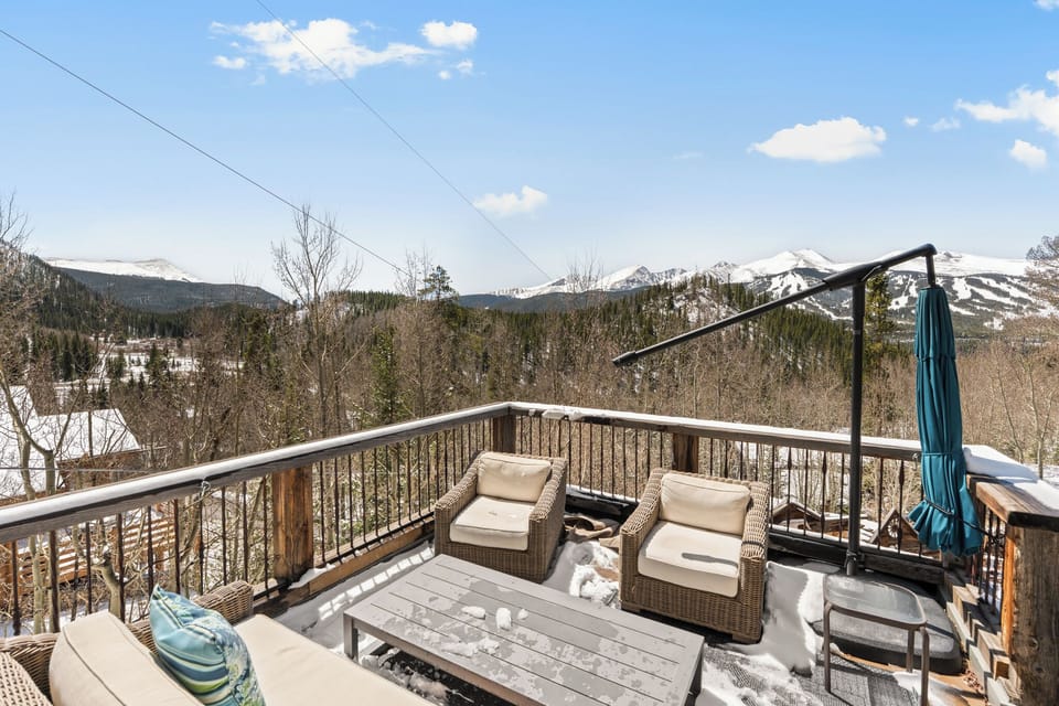 A private deck overlooking snow-capped peaks and forested valleys, perfect for morning coffee or evening relaxation surrounded by mountain beauty.