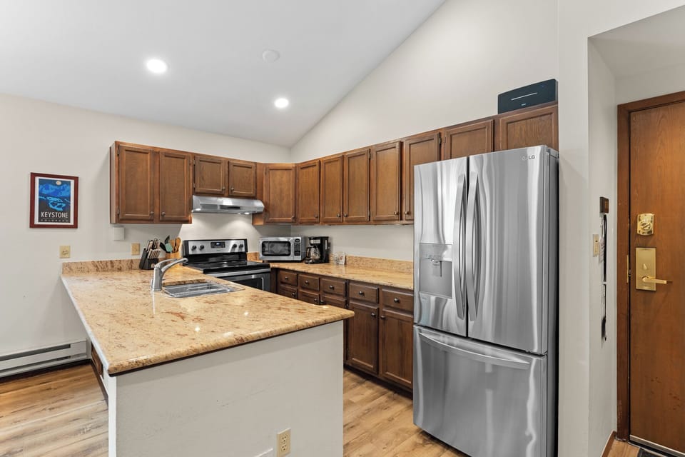Your well-appointed kitchen features granite countertops, stainless steel appliances, and a spacious center island—perfect for preparing home-cooked meals and gathering with loved ones during your mountain getaway.