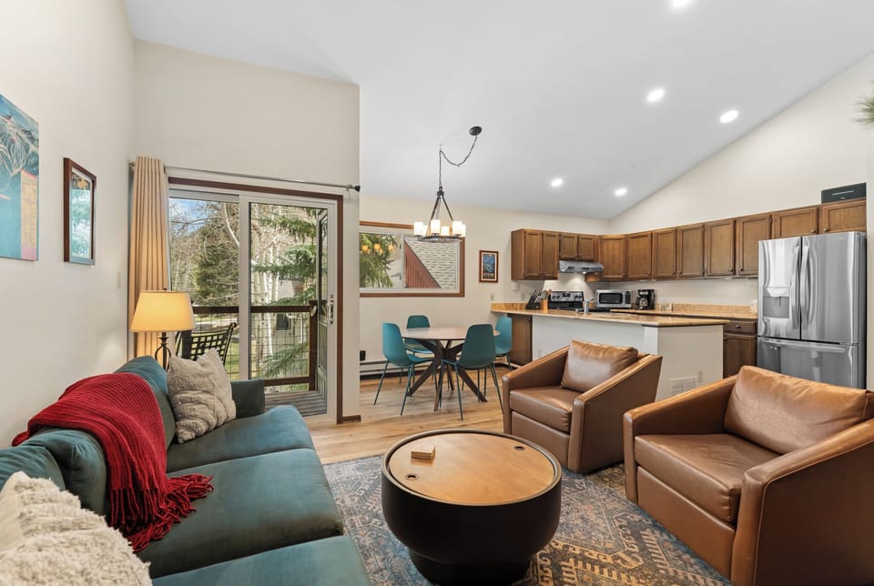 Settle into this bright, open-concept space where your living room flows seamlessly into a fully equipped kitchen. Natural light pours through the patio doors, inviting you to unwind on plush seating after a day of adventure.