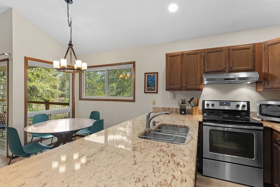 Your fully equipped kitchen features granite countertops and opens to a sunny dining area with serene garden views, perfect for preparing and enjoying home-cooked meals during your stay.