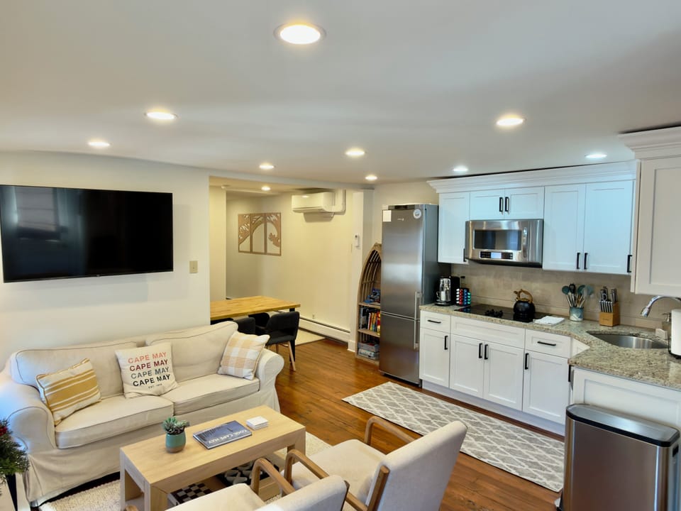 Sunny open-plan living with full kitchen, coffee bar, and smart TV lounge