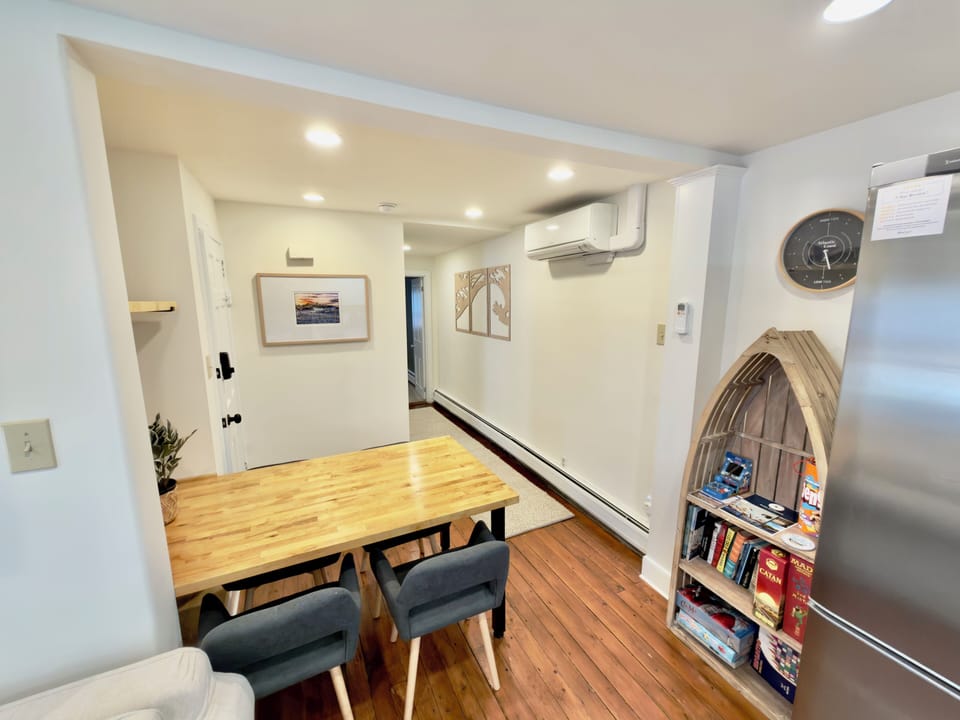 Bright dining nook with hardwood floors, board games, and AC comfort