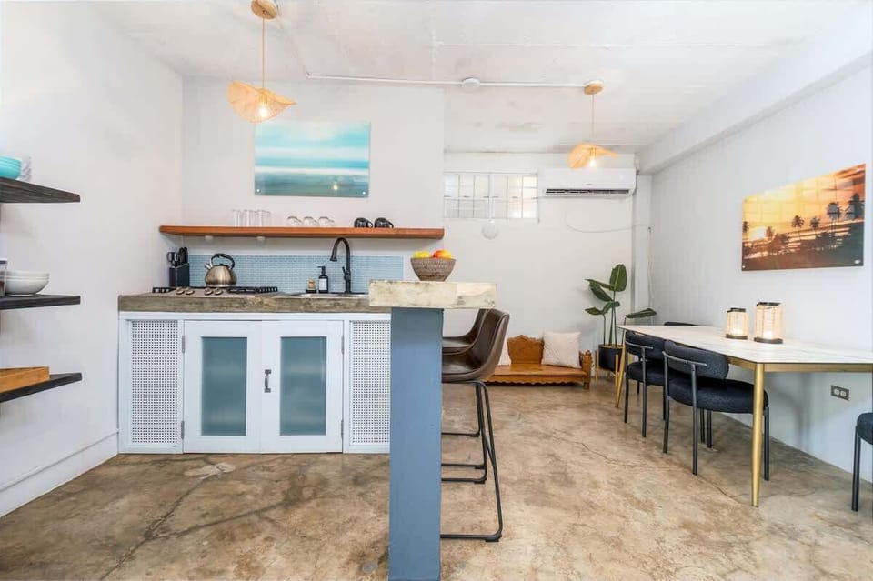 Modern kitchen and dining in Rincón, Puerto Rico — concrete counters, marble-top table, and tropical elegance for stylish stays