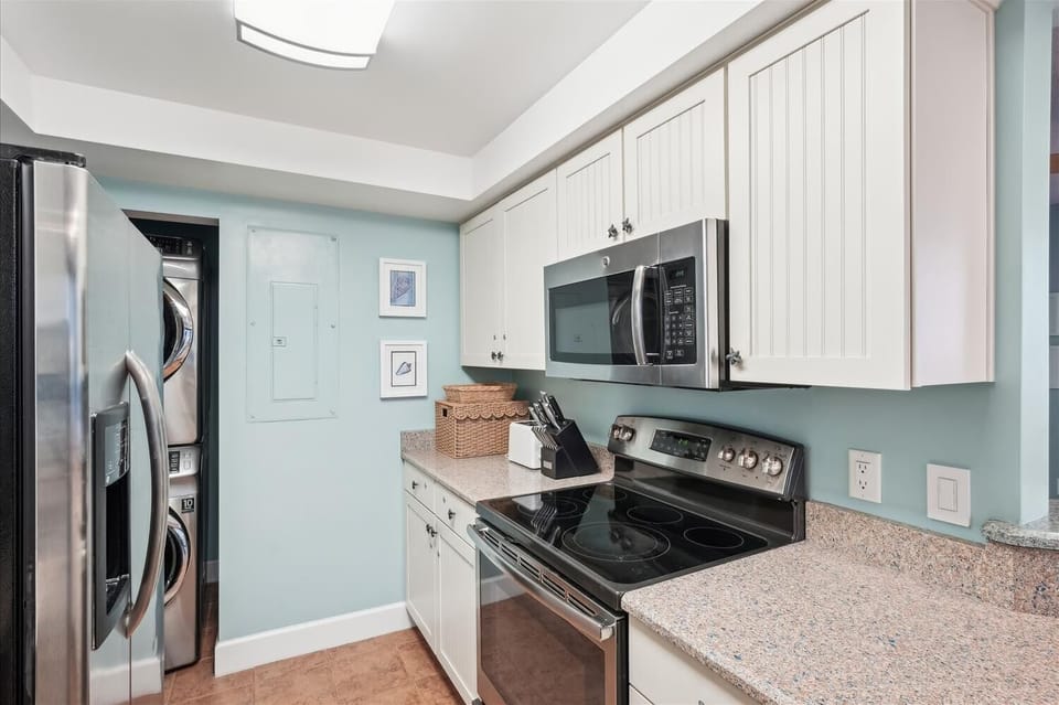 Your modern, fully-equipped kitchen features sleek stainless steel appliances, ample counter space, and a skylight that fills the room with natural light—perfect for preparing morning coffee or family meals.