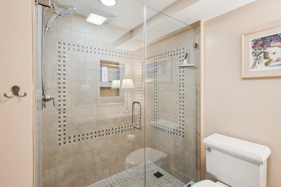 Step into your spa-inspired bathroom, where a spacious walk-in shower with beautiful mosaic tile details and multiple showerheads awaits to refresh you after each adventure.