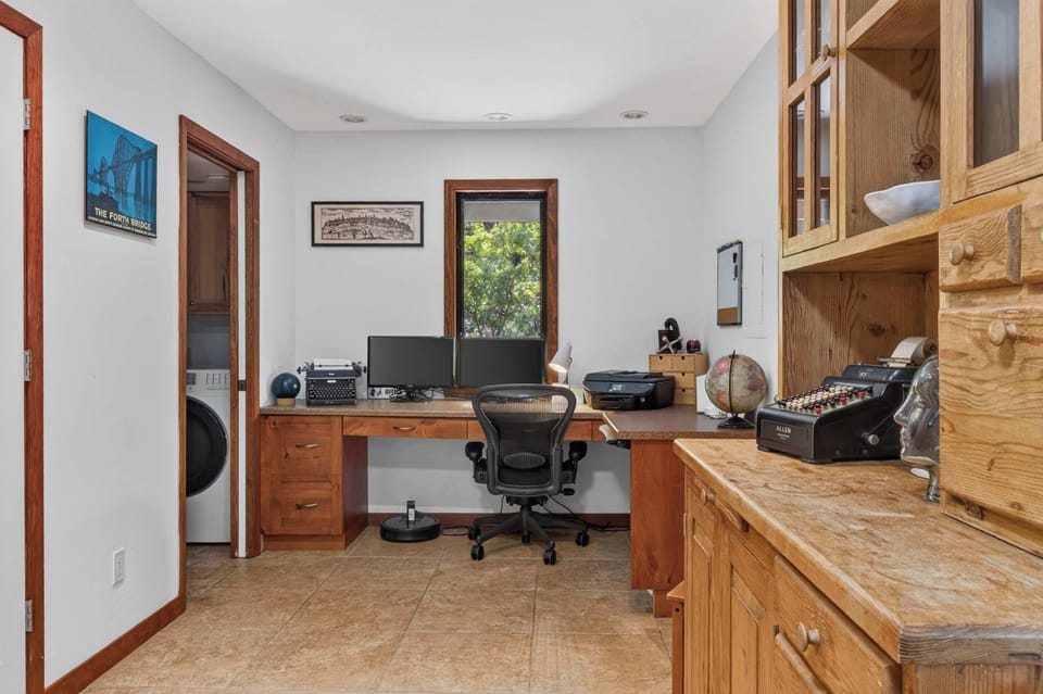 Need to log in? This tucked-away office pairs dual monitors with a leafy window view and laundry a step away.