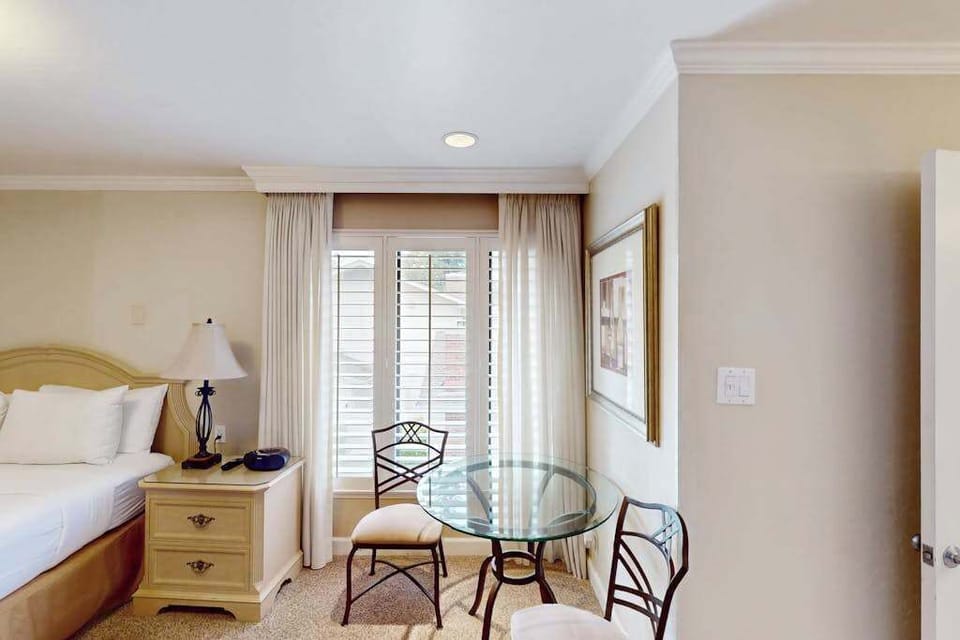 Enjoy a quiet glass of Napa Valley wine at the in-room bistro table with plantation shutters filtering the golden afternoon light.