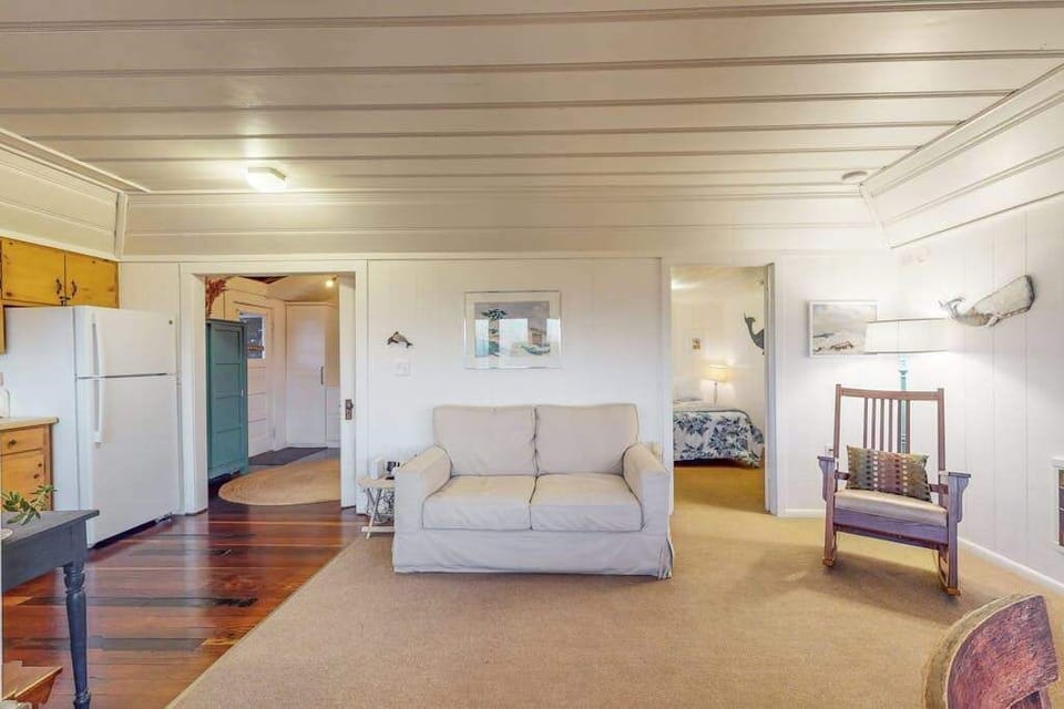 Spread out in your open-concept Bodega Bay living area with gleaming hardwood floors and doorways leading to two cozy bedrooms and the kitchen beyond.