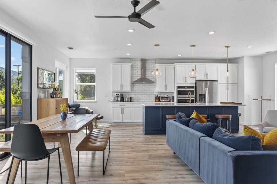 Open-concept living flows from chef's kitchen to dining bench, with navy island and subway tile anchoring the great room.