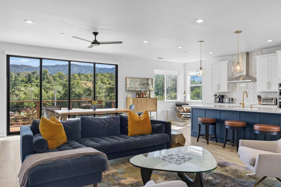 Floor-to-ceiling sliders frame the wooded hillside while you lounge with coffee and watch the valley wake up.
